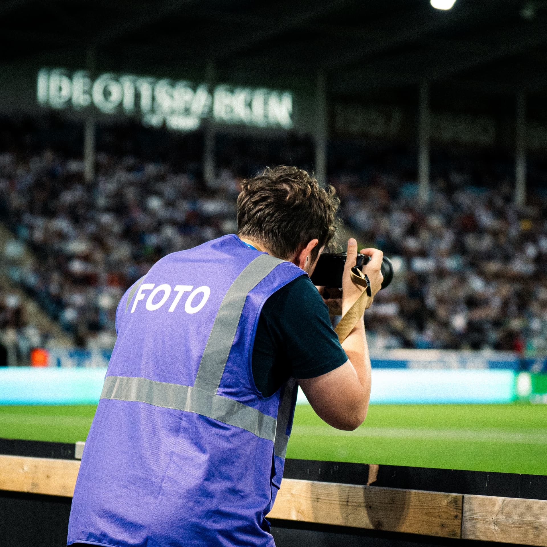Fotografen Anton Flis arbetar vid sidlinjen under en fotbollsmatch